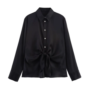 Detail of black satin shirt featuring a stylish knot design at the front hemline