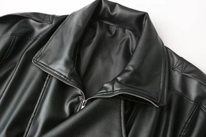 Détail d'une veste en cuir noir montrant la fermeture éclair et la texture du col