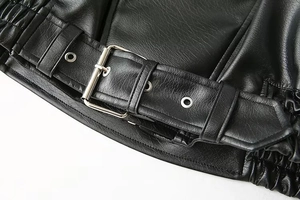 Détail de la taille d'une veste en cuir noir avec boucle argentée et ourlet élastique