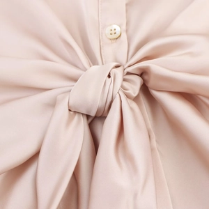 Elegant champagne satin shirt featuring a stylish knot design and pearl-style button detail