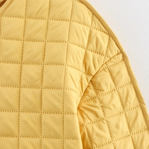 Women's yellow quilted jacket with diamond pattern padding and round neckline