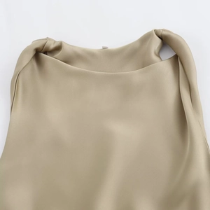 Detailed view of the champagne satin fabric with elegant draped neckline texture