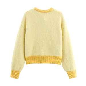Detail view of the back of a pale yellow knit cardigan with ribbed cuffs and hemline