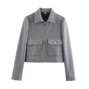 Detalle de chaqueta de lana gris con cremallera metálica y bolsillos de solapa