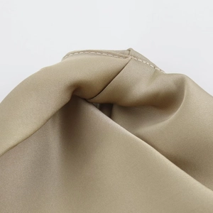 Close-up of the smooth satin fabric texture and neat stitching on a khaki midi dress