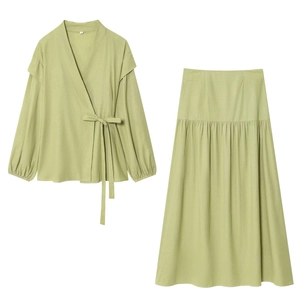 Detail of light green two-piece set featuring wrap tie top and flowy pleated maxi skirt