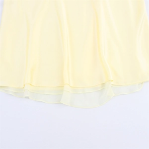 Detail eines hellgelben Chiffonkleides mit Lagen-Saum und zarter Textur