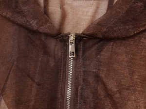 Close-up of a silver metal zipper on a dark brown sheer organza hooded jacket fabric