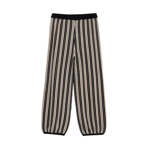 Detailed view of striped knit trousers with elastic waistband on white background