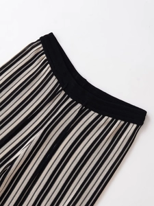 Detail of high-stretch vertical striped knit trousers with elastic ribbed waistband