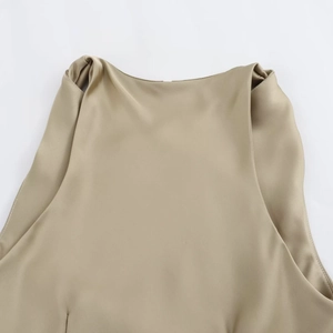 Detail of satin halter neck midi dress featuring smooth champagne glossy fabric finish