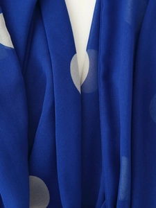 Vue macro du tissu à pois bleus avec texture en mousseline légère et drapé fluide