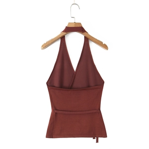 Detail of terracotta halter neck knit top featuring a crossover wrap design and V-neckline
