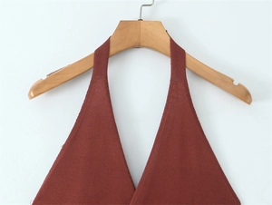 Detailed close-up of knit texture and halter neckline on a rust red knitted top