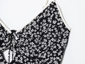 Detail of floral dress featuring V-neckline with white trim and drawstring front