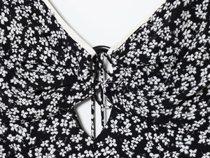 Detail of floral V-neck bodice featuring black ring hardware and hollow-out lace-up design