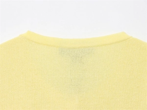 Close-up of ribbed crew neckline on a light yellow fine-knit summer sweater for women