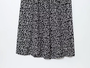 Detailed view of lightweight black fabric with white floral pattern and neat hem stitching