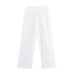 Dettaglio dei pantaloni bianchi a vita alta con gamba larga e ricamo a occhiello