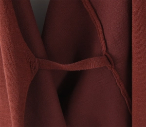 Detailed macro shot of coffee brown knit fabric texture and high-quality internal stitching