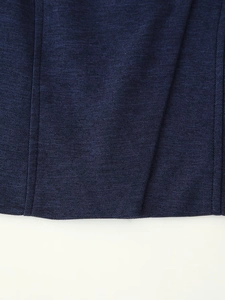 Détail du tissu côtelé bleu marine avec design croisé et coutures fines sur le gilet