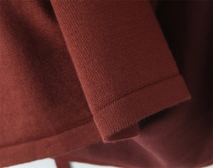 Detailed close-up of brown knit halter top fabric texture and ribbed edge finish