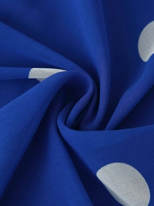 Gros plan du tissu mousseline bleu marine léger avec des motifs à pois blancs texturés