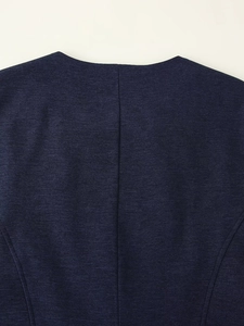 Gros plan sur tissu texturé bleu indigo montrant l'encolure ronde et la couture au dos