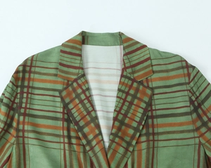Detail view of the notch lapel on a classic green and brown checkered blazer jacket