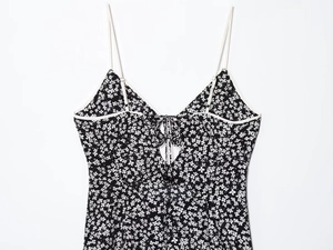 Detail of floral sundress featuring thin straps and back lace-up cutout design