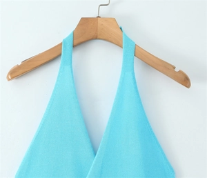 Detail of light blue halter knit top showing fine texture and neckline on a wooden hanger