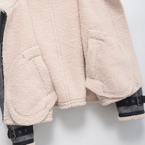 Chic cream faux shearling jacket with contrast gray cuffs and black leather buckles