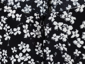 Close-up of black invisible zipper on French floral summer dress with white prints