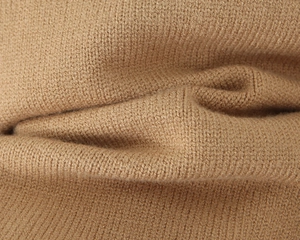 Vista macro dettagliata della trama del tessuto in maglia cammello e dettagli di tessitura