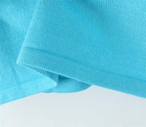 Close-up of high-quality light blue knitted fabric showing detailed stitching and soft texture