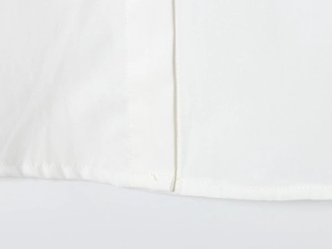 Detail view showing professional neat stitching on white cotton shirt hemline and fabric