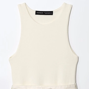 Off-white sleeveless ribbed tank top with crew neck and internal brand tag detail