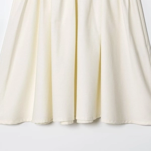 Elegant cream pleated A-line dress with diagonal stitching and waist belt detail