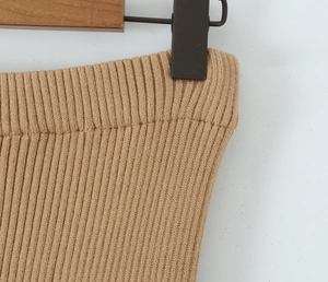 Dettaglio vita dei pantaloni in maglia color cammello con elastico e gruccia