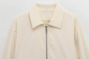 Detail of the spread collar and silver metal zipper on this cream-colored jacket