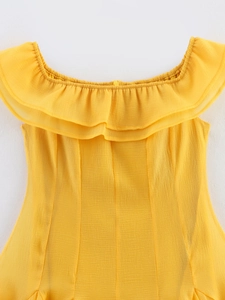 Détail d'une robe jaune à épaules dénudées avec décolleté à volants et tissu texturé