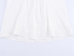 Close-up of the white sleeveless top showing vertical textures and hollow lace embroidery