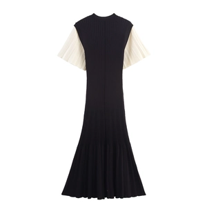 Détail de la robe en maille montrant la texture côtelée noire et les manches courtes crème