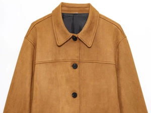 Détail d'une veste en daim marron avec col à revers et boutons ronds noirs élégants