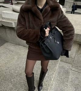 Detailaufnahme einer dunkelbraunen Kurzjacke aus Kunstpelz mit Reverskragen und Streetstyle