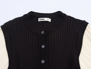 Détail d'une robe en maille avec texture côtelée, manches en dentelle et boutons en relief