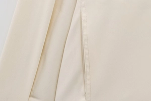 Macro view of high-quality twill fabric texture and precise stitching on beige jacket