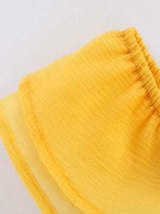 Détail macro du tissu crépon jaune avec couture élastique nette et précise