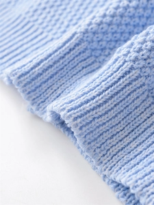Detail of light blue waffle knit texture and ribbed hem on a stylish knit vest