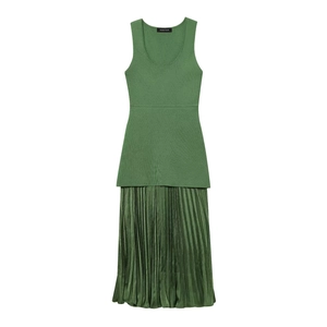 Dettaglio del corpetto in maglia senza maniche verde scuro e gonna a pieghe